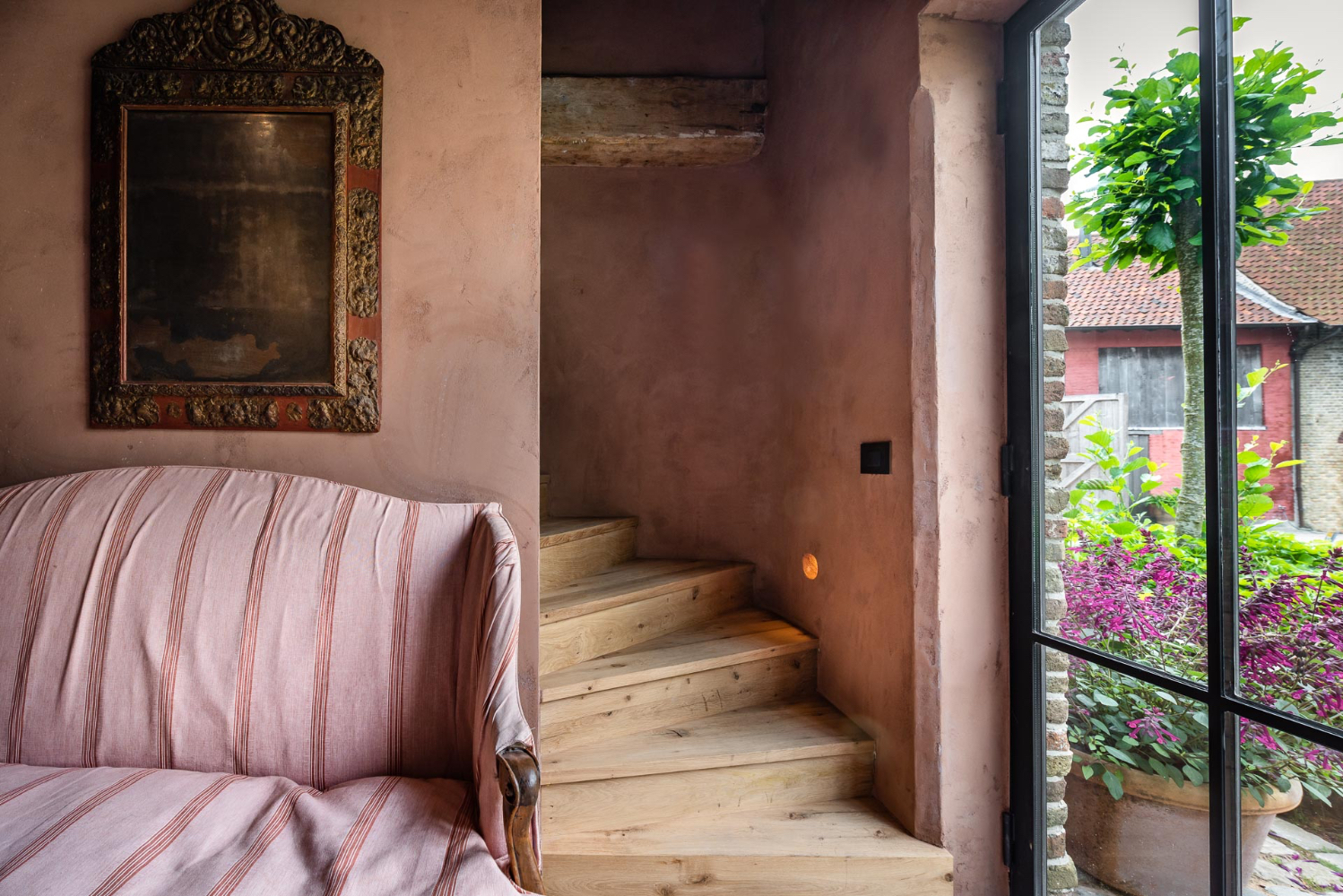 Rosy plaster walls, character rich wood steps, and exquisitely decorated interiors grace The Little Monastery, a B&B by Brigitte Garnier. Come see more!
