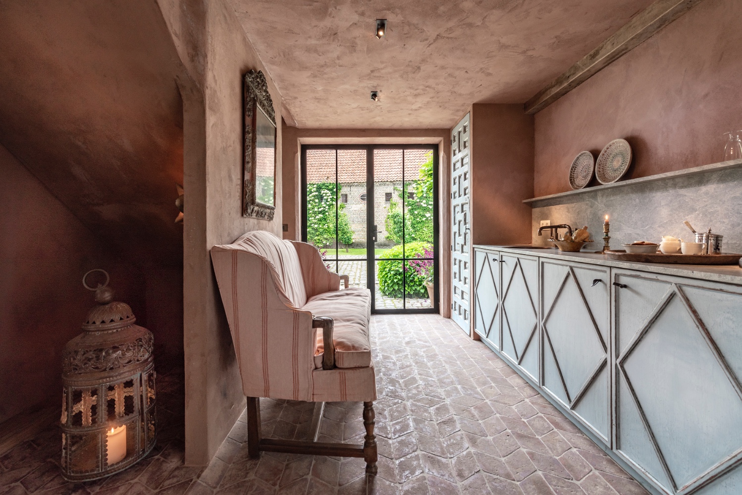 Warm rosy plastered walls and ceiling in a Belgian style interior at The Little Monastery. Come enjoy photos of Old World Style and Rustic European Antiques in a Serene Countryside Setting.