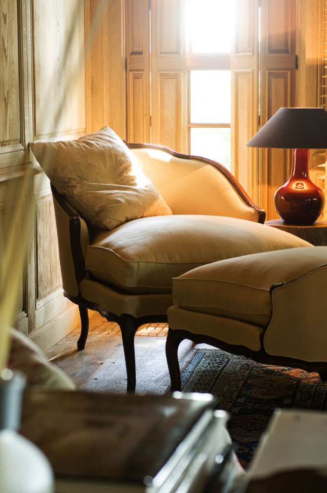 A breathtaking vignette with natural light, a curvy chair, and gourd style lamp in a Belgian style interior at The Little Monastery. Come enjoy photos of Old World Style and Rustic European Antiques in a Serene Countryside Setting.